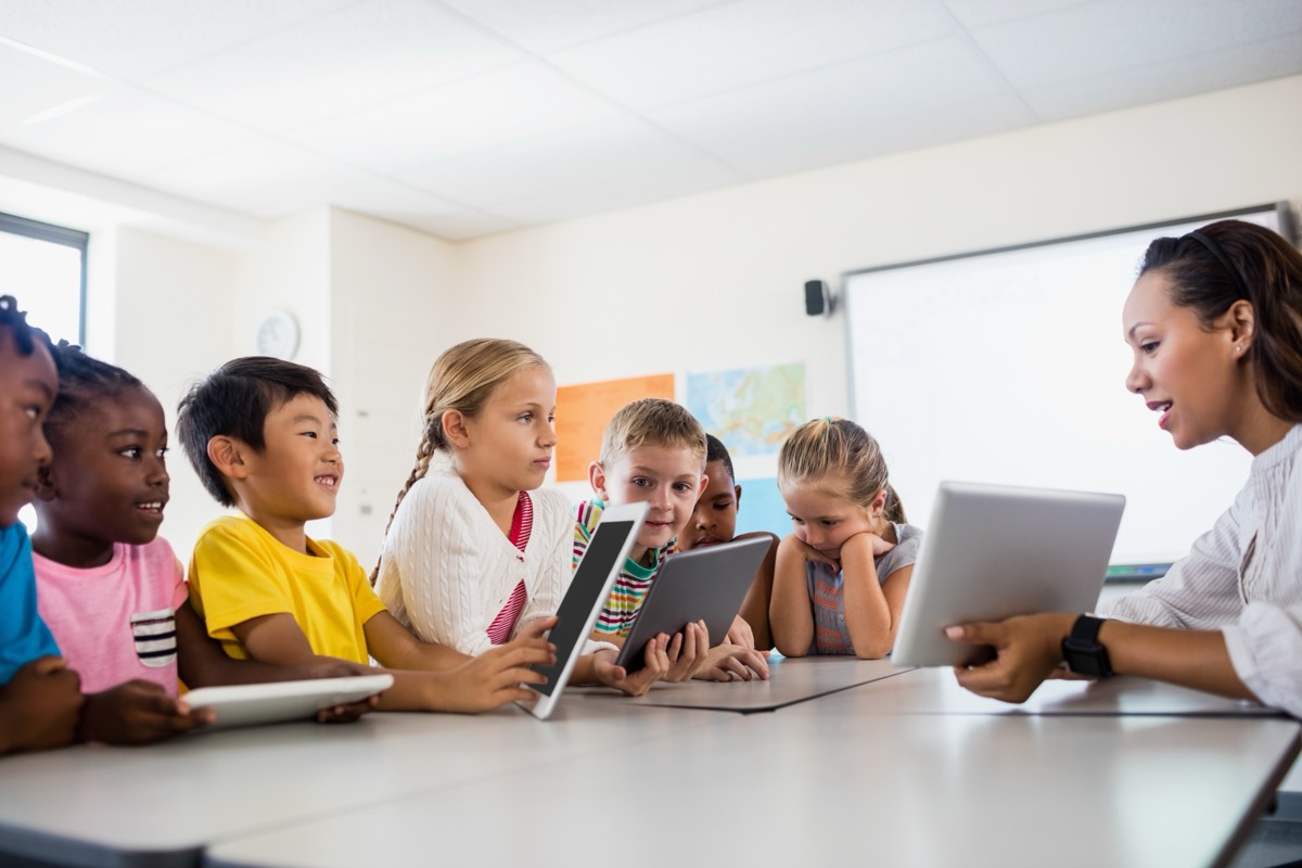 Teacher and students using tablets in classroom